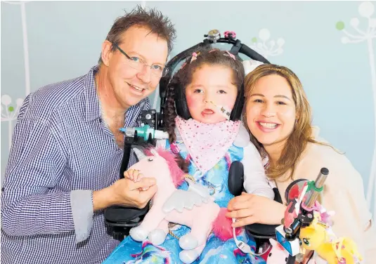  ??  ?? Ana-Carolina, pictured with her parents Peter Bircham and Elane de Moraes Lobo, has spent almost all of her life in paediatric intensive care.