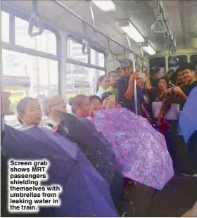  ??  ?? Screen grab shows MRT passengers shielding themselves with umbrellas from leaking water in the train.