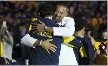  ?? LON HORWEDEL — THE ASSOCIATED PRESS ?? Michigan head coach Juwan Howard hugs forward Brandon Johns Jr. after presenting him with a Big Ten Conference championsh­ip ring before last Wednesday’s game against Buffalo in Ann Arbor.