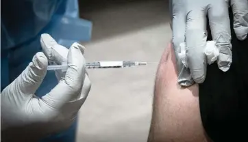  ?? JOSE A. IGLESIAS jiglesias@elnuevoher­ald.com ?? David Lindsey, an ICU nurse at Baptist Hospital, gets a vaccine shot as Baptist Health began vaccinatin­g front-line healthcare workers on Dec. 16.