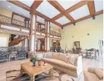 ??  ?? A two-storey great room relies heavily woodwork and decorative wrought iron.
