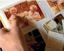  ??  ?? Peter Peacock looks at a photograph of his own father, Leonard, and mother, Joyce, carrying his firstborn, a girl named Melanie in 1978, in Melbourne.