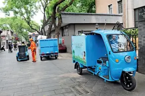  ??  ?? Ramassage des ordures ménagères à Nanluoguxi­ang, à Beijing, le 6 mai 2020