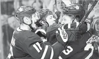  ?? FRANK GUNN THE CANADIAN PRESS FILE PHOTO ?? Toronto Maple Leafs defenceman Travis Dermott, right, is mobbed by teammates after scoring his first NHL career goal. The Leaf defencemen feel they are ready to go and will keep improving.