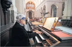  ?? FRANÇOIS MORI THE ASSOCIATED PRESS ?? An organist in a Paris church wears a protective shield during service. France is gradually lifting its lockdown on churches after a legal challenge to the closures.