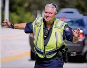  ??  ?? Schools Officer Bob Keating is back to work directing traffic at the entrance to Wellington Landings Middle School. He was hit by a distracted parent last December.