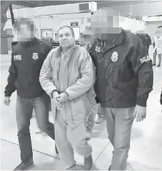  ??  ?? Guzman (centre) being escorted by US Drug Enforcemen­t (DEA) personnel as he is extradited to US in an unknown location. — AFP photo