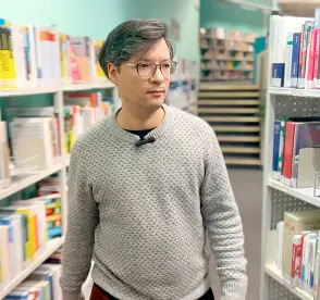  ?? ?? Rickum walks past shelves in the library.