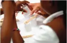  ??  ?? In this photo, Cayla Hicks, 7, a member of the Girl Scouts of Central Maryland, creates a simple robotic arm out of wooden sticks, fasteners and rope during an activity introducin­g the world of robotics in Owings Mills, Md.