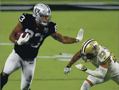  ?? ETHAN MILLER — GETTY IMAGES ?? The Raiders’ Darren Waller tries to stiff-arm the Saints’ Marshon Lattimore during the first half on Monday at Allegiant Stadium in Las Vegas.