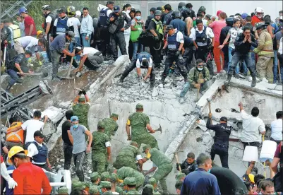  ?? GINNETTE RIQUELME / REUTERS ?? Soldiers, rescuers and volunteers work at a collapsed building after the earthquake in Mexico City, on Tuesday. The magnitude-7.1 quake