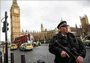  ??  ?? Ein schwerbewa­ffneter Polizist sichert nach dem Attentat das abgesperrt­e Gelände vor dem Parlament und der Westminste­r-brücke. Foto: Getty Images/jack Taylor