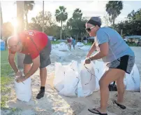  ?? AP ?? People filling sandbags to prepare for the hurricane. —
