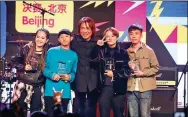  ??  ?? Paul Yan (center), a judge of the contest and a music producer from Taiwan, awards trophies to some of the individual winners, including singer-songwriter Ouyang Haopeng (first right).
