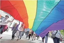  ?? MIKE DE SISTI/USA TODAY NETWORK ?? A group carries a Pride flag during the Milwaukee Pride Parade on Sunday.