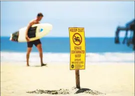  ?? K.C. Alfred San Diego Union-Tribune ?? A SIGN warns of sewage contaminat­ion off Imperial Beach, where the water is routinely closed because of cross-border pollution flowing from the Tijuana River.