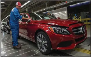  ?? (AFP via Getty Images/TNS/ Andrew Caballero-Reynolds) ?? An employee does final inspection­s on a Mercedes-Benz C-Class at the Mercedes-Benz U.S. Internatio­nal factory in Vance, Ala.