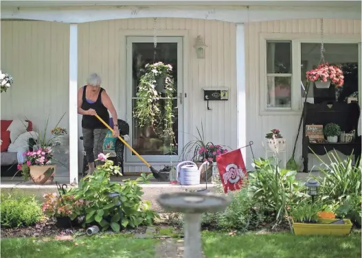  ?? COURTNEY HERGESHEIM­ER/COLUMBUS DISPATCH ?? Ann Solis cleans off her front porch. “It’s a good neighborho­od,” she says of Lincoln Village.