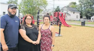  ?? COLIN MACLEAN/JOURNAL PIONEER ?? Ricky, left, and Ashley Arsenault, right, stand with their friend, Sara Gallant, at Billy Bridges Park in Summerside. They have concerns about the type of material used as ground cover around the city’s new accessible play structure.