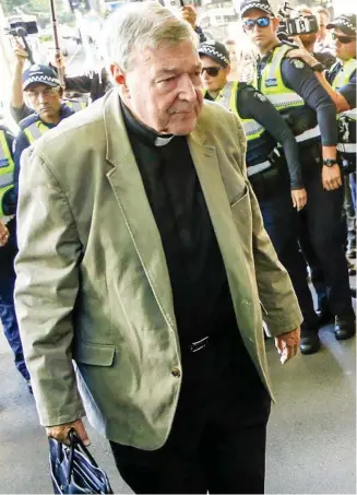  ?? PHOTO: ASANKA BRENDON RATNAYAKE/AP ?? PLENTY OF POLICE: Cardinal Pell arrives at court yesterday.