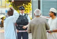  ?? THE ASSOCIATED PRESS ?? A police officer talks to local people in North London on Monday after a man crashed a van into a crowd of pedestrian­s outside a small mosque.