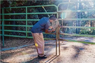  ?? ?? Darryl Lucien opens an entrance gate to land at Emigrant Gap in September. Founder Jade Stevens says the land the Conservati­on League is buying is filled with lakes, miles of trails and other opportunit­ies for outdoor recreation.