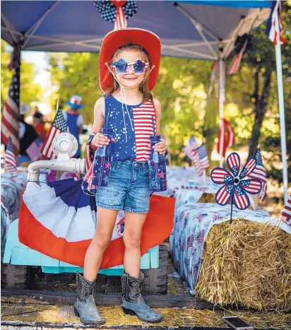  ??  ?? Kinley Warrick, 6, donned her best Fourth of July outfit aboard a float owned by her family during the Corrales Fourth of July parade on Thursday.