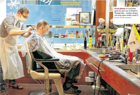  ?? PHOTO: FRANK McGRATH ?? A cut above: A customer gets his hair cut in Dublin’s Temple Bar – barber shops can stay open under Level 3.