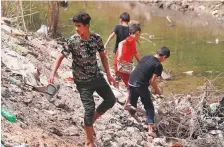  ?? AFP ?? Iraqi youths gather on the banks of a drying and polluted ■ stream in Najaf province.