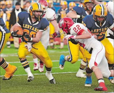  ?? DANA JENSEN/THE DAY ?? Ledyard’s Alex Manwaring (30) finds a hole and cuts across the field to avoid Wolcott’s Patrick Byrne (22) during the Colonels’ 35-0 win in the 2011 CIAC Class M semifinals at Middletown High School.