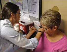  ??  ?? Above: Cindy Gibbs receives a quadrivale­nt flu shot from Shalane Lamb, RNBSN, at the Walker County Health Department in LaFayette. The shot will lessen the likelihood of contractin­g seasonal influenza. Left: A measured dose of Prevnar 13 is...