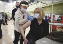  ?? AL SEIB/LOS ANGELES TIMES ?? Teacher Abigail Abbott, 65, gets her COVID-19 vaccinatio­n from nurse practition­er Jiyoun Cho, left, on Feb. 17 in Los Angeles.