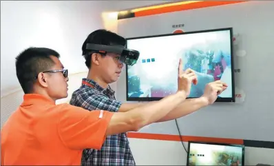  ?? LI XIN / XINHUA ?? Participan­ts try mixed reality technology applicatio­ns at the 25th China Internatio­nal Financial Exhibition held from July 27 to 30 in Beijing.