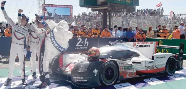  ?? — AFP ?? (From L) New Zealand’s Brendon Hartley, Earl Bamber and Germany’s Timo Bernhard take a selfie with their Porsche 919 Hybrid N°2, after winning the 85th Le Mans 24-hours endurance race in Le Mans.