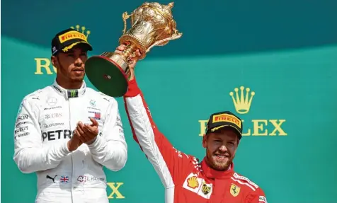  ?? Foto: Martin Rickett, dpa ?? Mit seinem Sieg in Silverston­e baut Sebastian Vettel (rechts) seine WM Führung vor Lewis Hamilton aus.