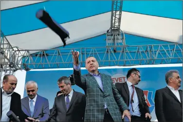  ?? AP/LEFTERIS PITARAKIS ?? Turkish President Recep Tayyip Erdogan hands out souvenirs to supporters on Saturday in Istanbul after his speech at the last rally before today’s referendum on expanding presidenti­al powers.