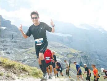  ?? (CONTRIBUTE­D FOTO) ?? WHAT A VIEW. The author leads a group of runners as they tackle a steep ascent in the Jungfrau Marathon.