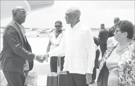  ??  ?? President David Granger (centre) greets Prime Minister of Trinidad and Tobago, Dr. Keith Rowley upon his arrival. Also photograph­ed is Amna Ally. (Ministry of the Presidency photo)