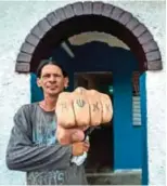  ?? ?? AIDS patient Gerson shows his tattooed fist at home, a former sanatorium for HIV patients.