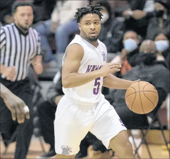  ?? MICHAEL GARD/POST-TRIBUNE ?? Hammond’s Reggie Abram moves the ball upcourt during a game against Merrillvil­le in the Mac Jelks Invitation­al at Bowman on Jan. 2.