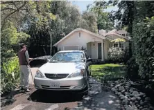  ?? Liz Hafalia / The Chronicle ?? A man hoses off his car at a home in Atherton, where Facebook, with offices in nearby Menlo Park, is helping to fill city coffers.