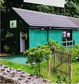  ??  ?? From opposite: a grass path winds through the flowers, shrubs and herbs; a tray of camomile ready for drying; the Iona Herbal building, painted green and bedecked with hanging baskets and pots, is at the heart of the garden