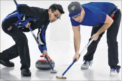  ?? DAVID JALA/CAPE BRETON POST ?? Mark MacNamara, left, and the aptly named Travis Stone sweep a rock during the last end of the final game of the 2018 Nova Scotia Travelers Club Curling championsh­ip that wrapped up at the Sydney Curling Club on Monday. Along with skip Kurt Roach and...
