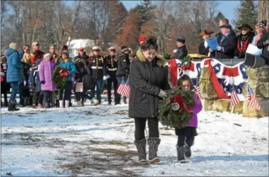  ?? PETE BANNAN – DIGITAL FIRST MEDIA ?? Karen and Maddie Rogers of Malvern carry a wreath to the mass grave at the Paoli Battlefiel­d Memorial Grounds.