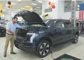  ?? MIKE STOCKER/SOUTH FLORIDA SUN SENTINEL ?? David Menten, president of Sawgrass Ford in Sunrise, shows some of the features of a Ford F-150 Lightning in the showroom of his dealership.