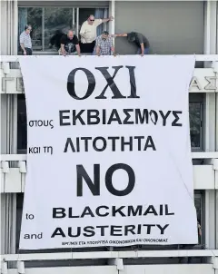  ?? REUTERS ?? Staff at the Ministry of Finance and National Economy stand by a banner unfolded from a balcony of the ministry in Athens on Wednesday.