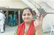  ?? — AFP ?? A voter shows both of her inked fingers after casting her ballot at a re-polling centre at Nava Naroda on the outskirts of Ahmedabad on Sunday.