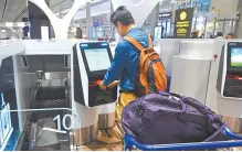  ?? AFP-Yonhap ?? A passenger checks in his luggage using an automated booth at the newly-opened Changi Internatio­nal Airport’s Terminal 4 in Singapore, Tuesday.