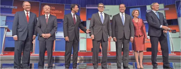  ?? MANDEL NGAN, AFP/GETTY IMAGES ?? Republican presidenti­al hopefuls, from left, Jim Gilmore, Lindsey Graham, Bobby Jindal, Rick Perry, Rick Santorum, Carly Fiorina and George Pataki arrive on stage for the start of the Republican presidenti­al primary debate Thursday in Cleveland.