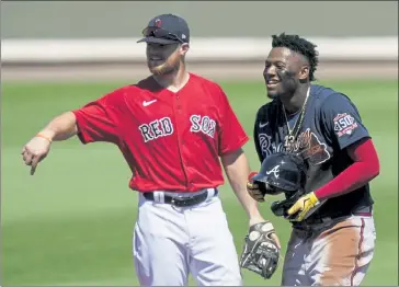  ?? BRYNN ANDERSON / AP ?? Christian Arroyo, left, laughs with Braves' Ronald Acuna Jr. in the first inning on Monday at JetBlue Park in Fort Myers.